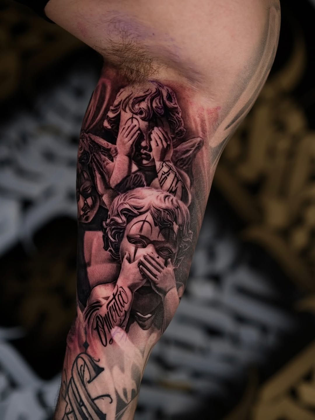 Three cherubs with hands over faces, dramatic grayscale shading