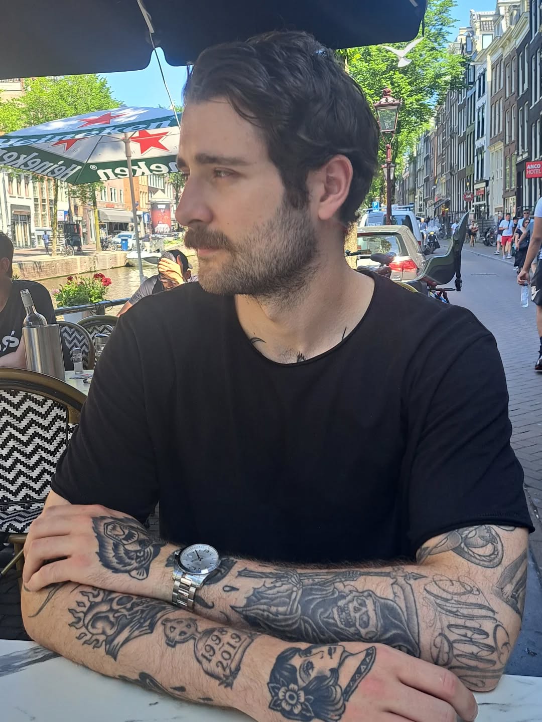 Bold black-and-gray sleeve featuring skulls and portraits.