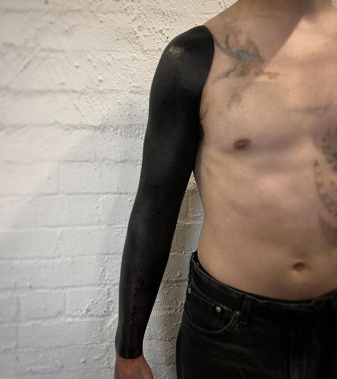 Complete arm blackout with solid, glossy black fill.