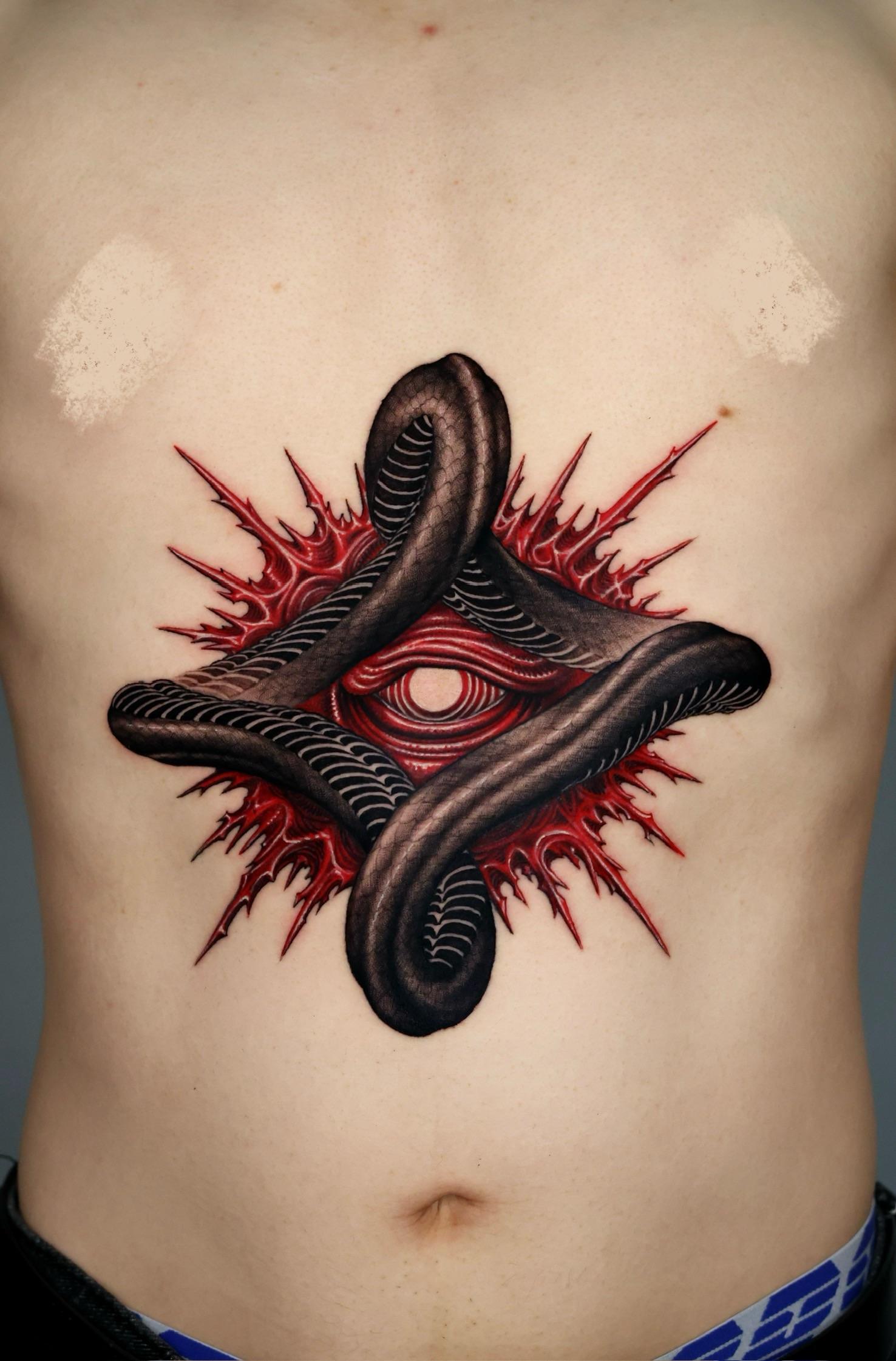 Interwoven black serpents frame a crimson, eye-like core