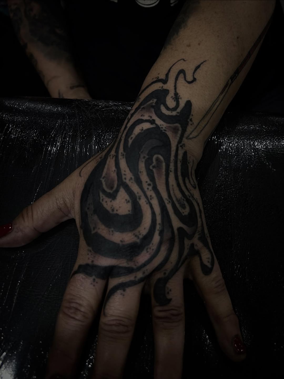 Bold blackwork abstract swirls with dot splatter.