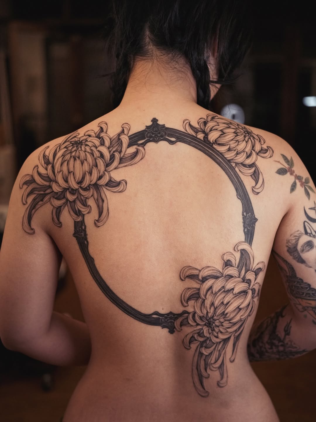 Chrysanthemum blossoms encircle a bold ornamental ring.