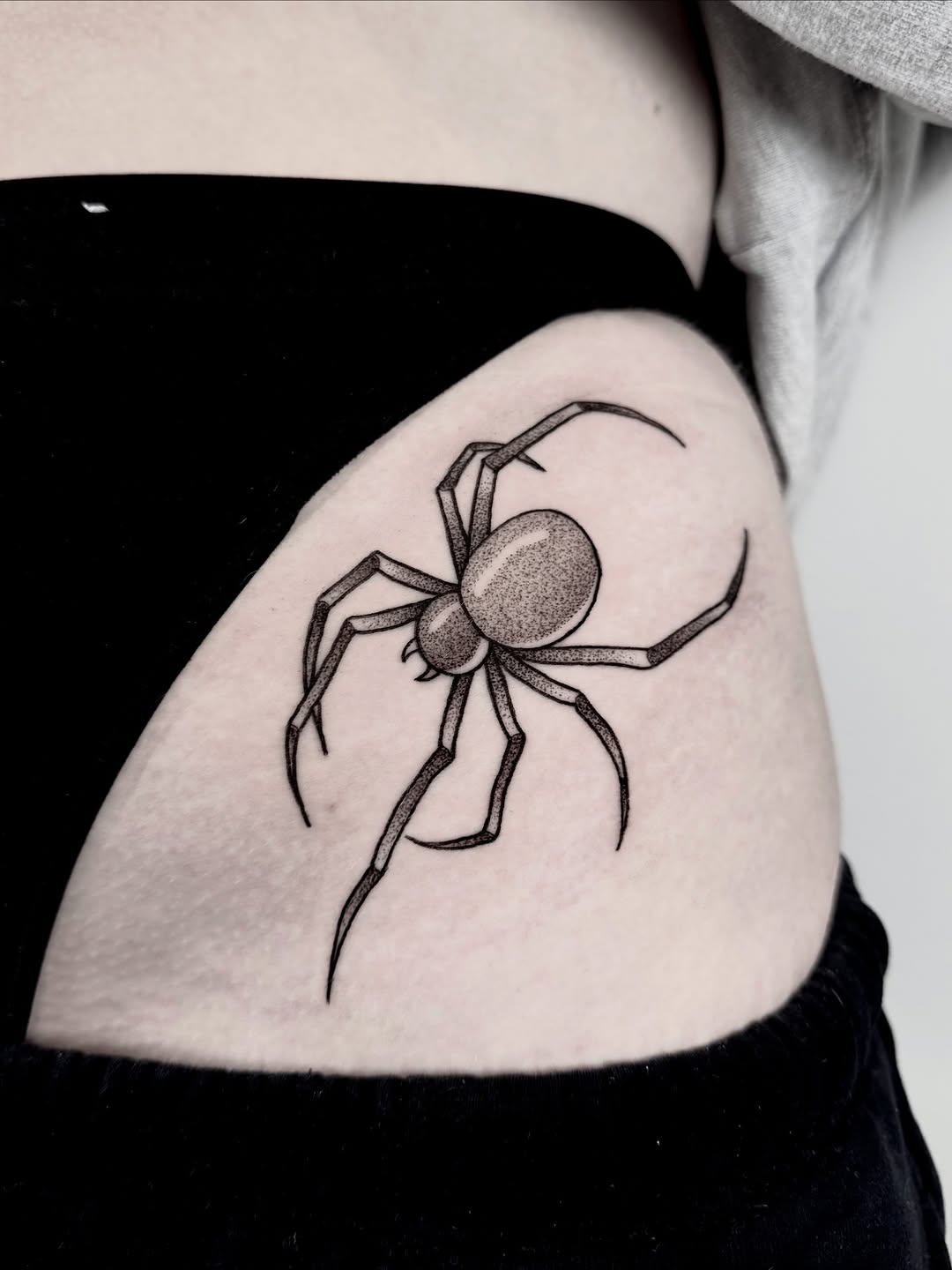 Crisp blackwork spider with stippled abdomen and bold linework