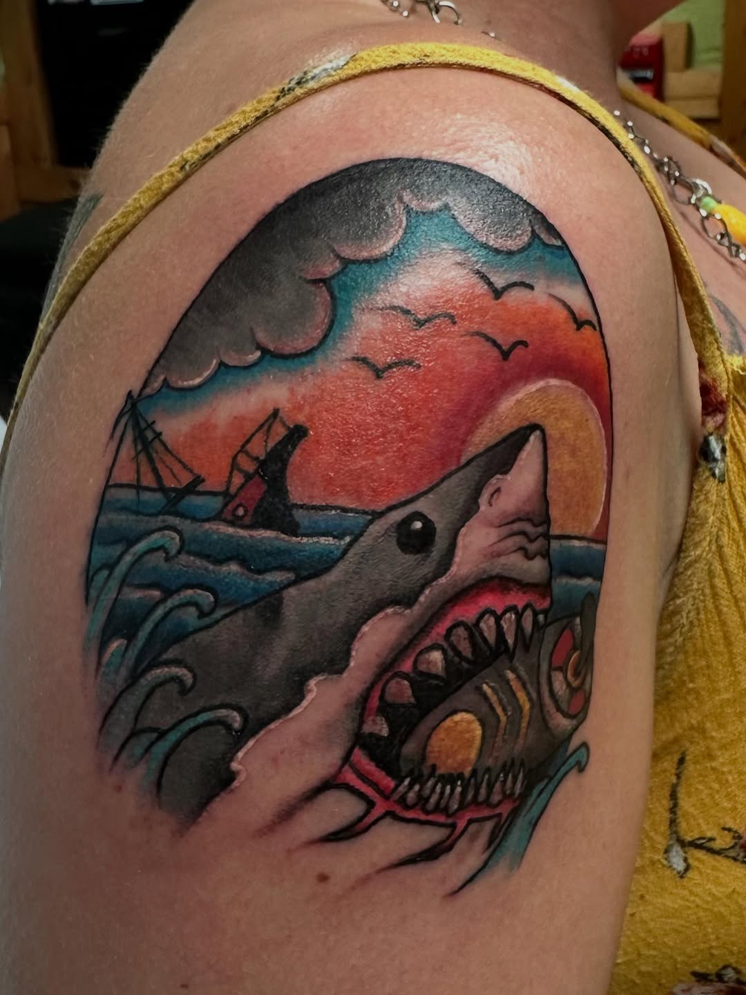 Bold neo-traditional shark prowling turquoise waves under sunset.