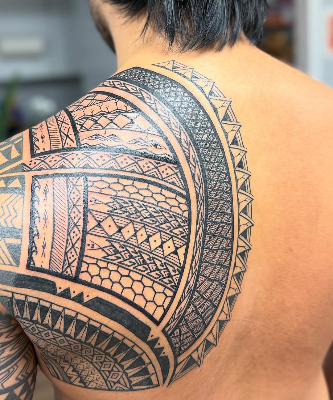 Intricate circular-band Polynesian-inspired blackwork sleeve with geometric motifs