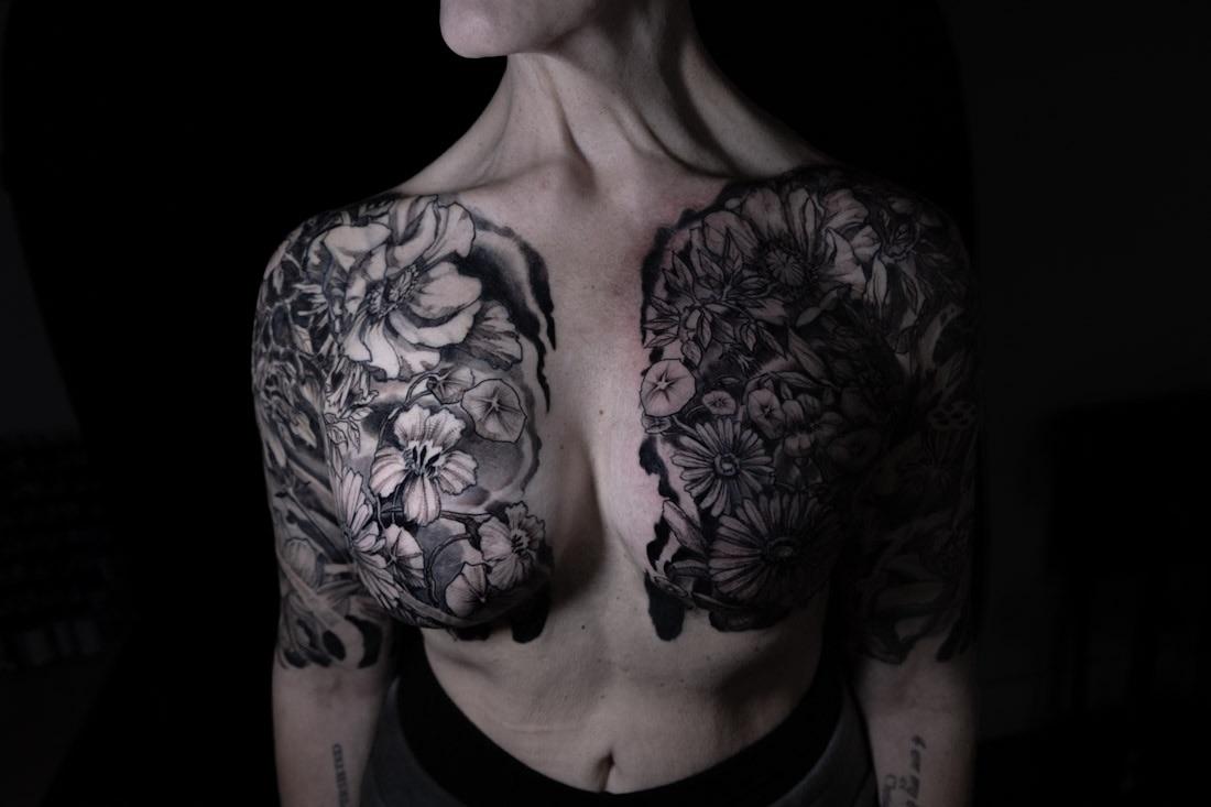 Dramatic black-and-gray floral chest cover-up with bold shading