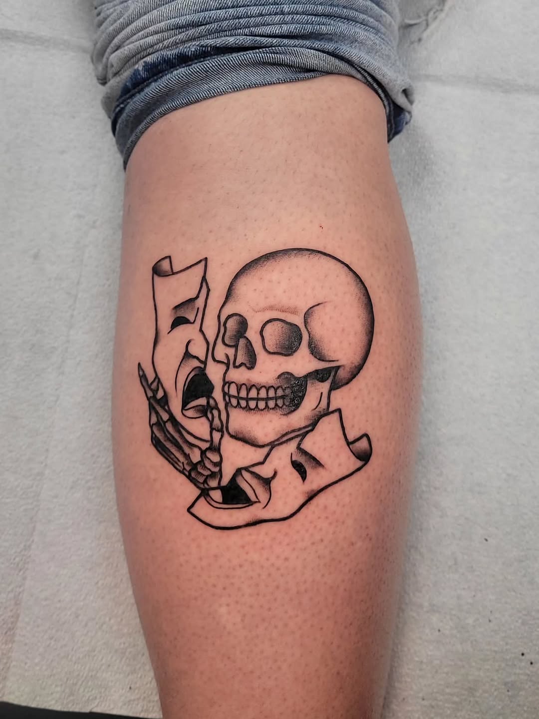 Bold skull with torn parchment banners, stark linework