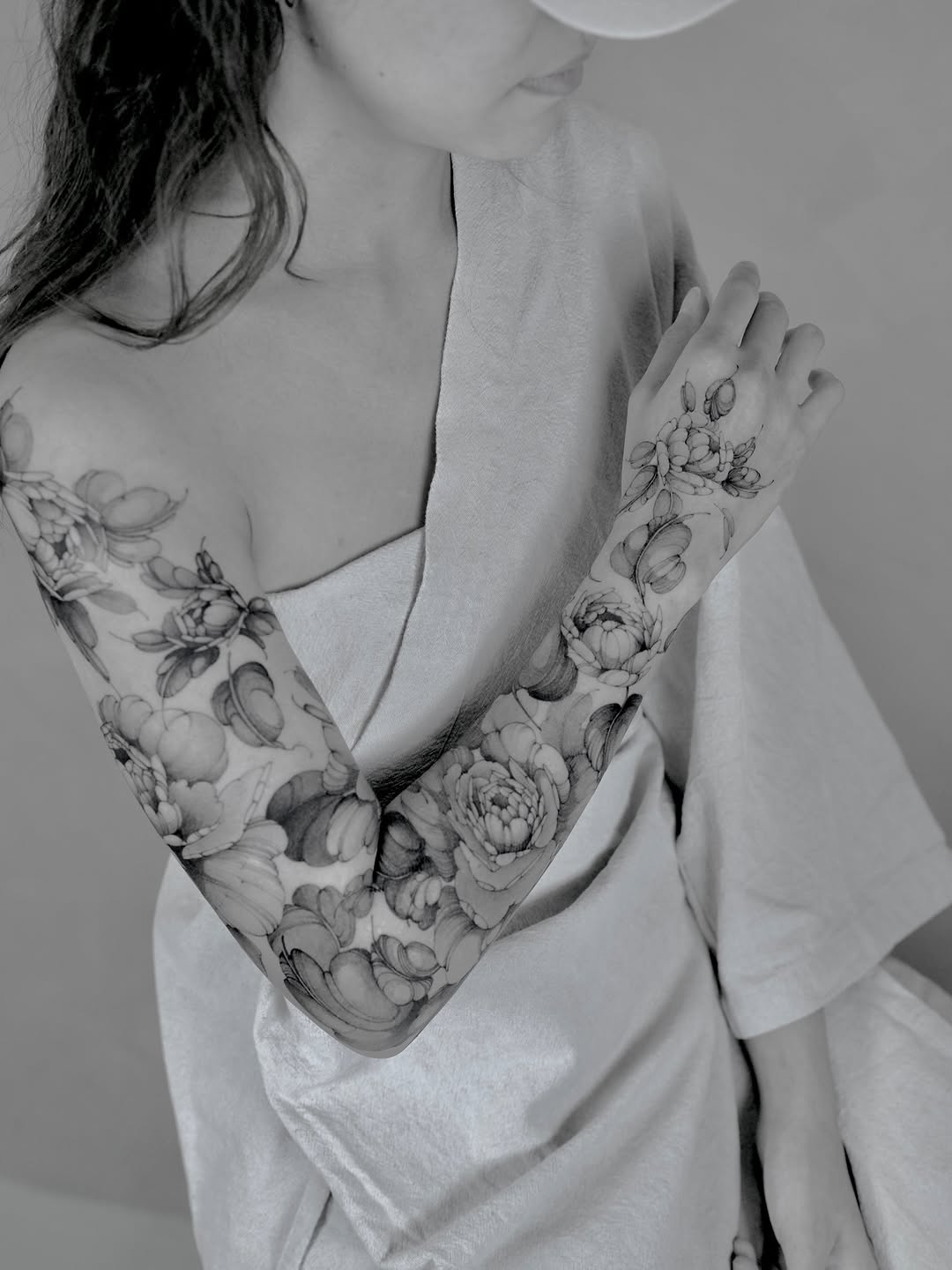 Delicate black-and-gray peony sleeve with fine-line shading.