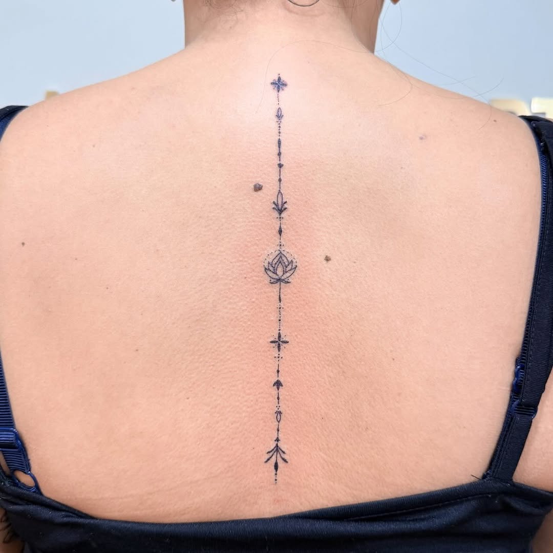 Elegant fine-line spine lotus with dotted vertical accents