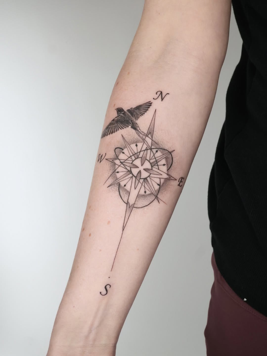 Delicate compass rose with geometric star and bird.