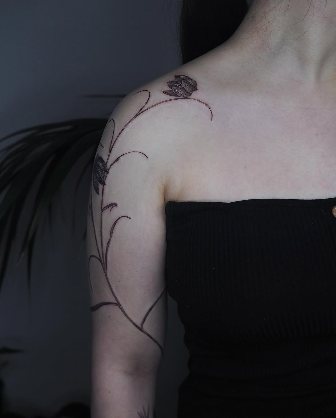 Delicate snake's-head fritillary-inspired floral vine along shoulder.