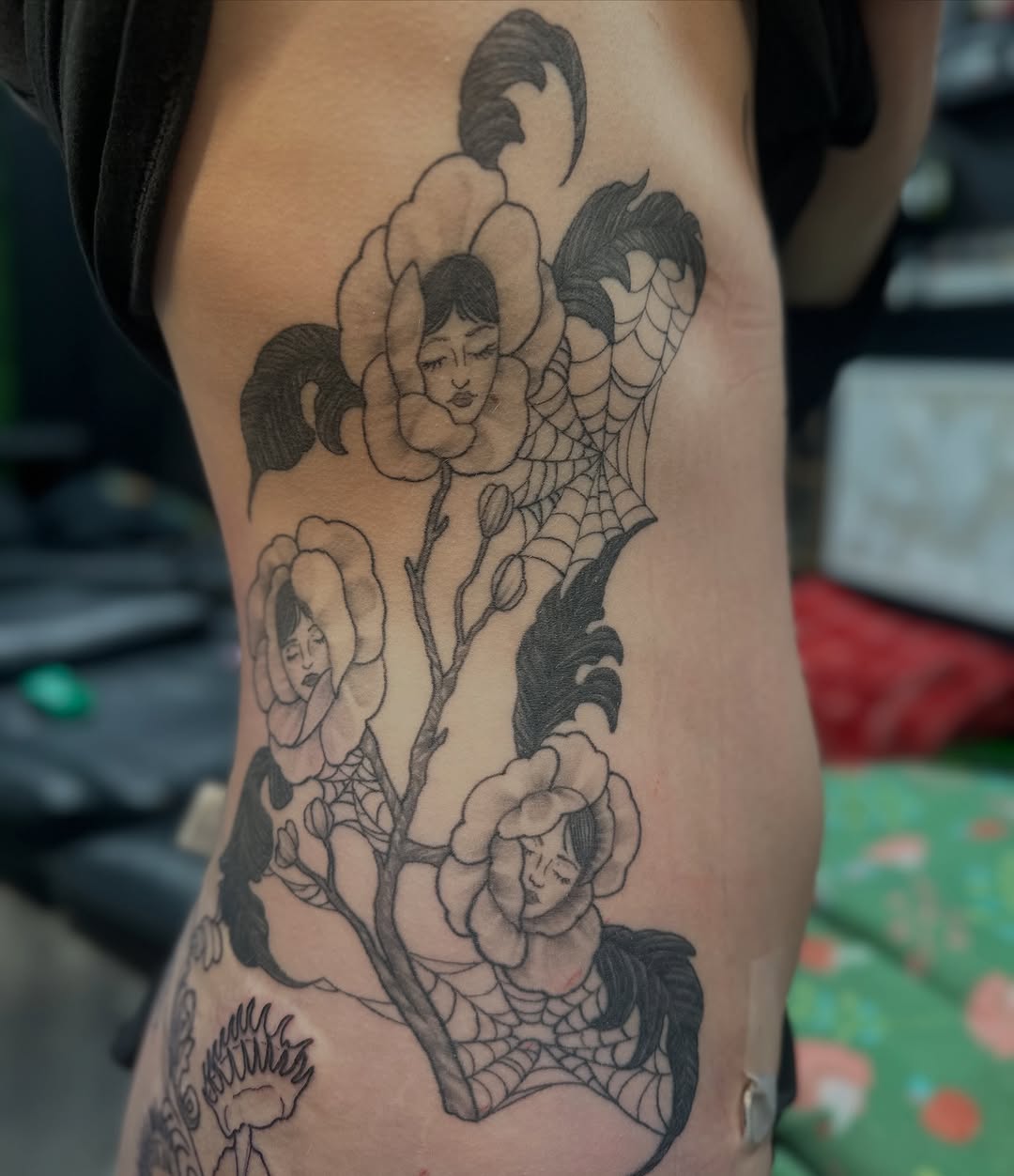 Floral rib piece with face-filled blossoms, intricate linework