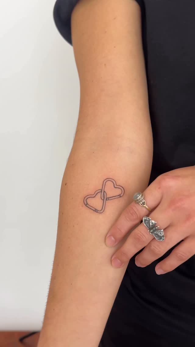 Interlocking heart outline in delicate fine-line style