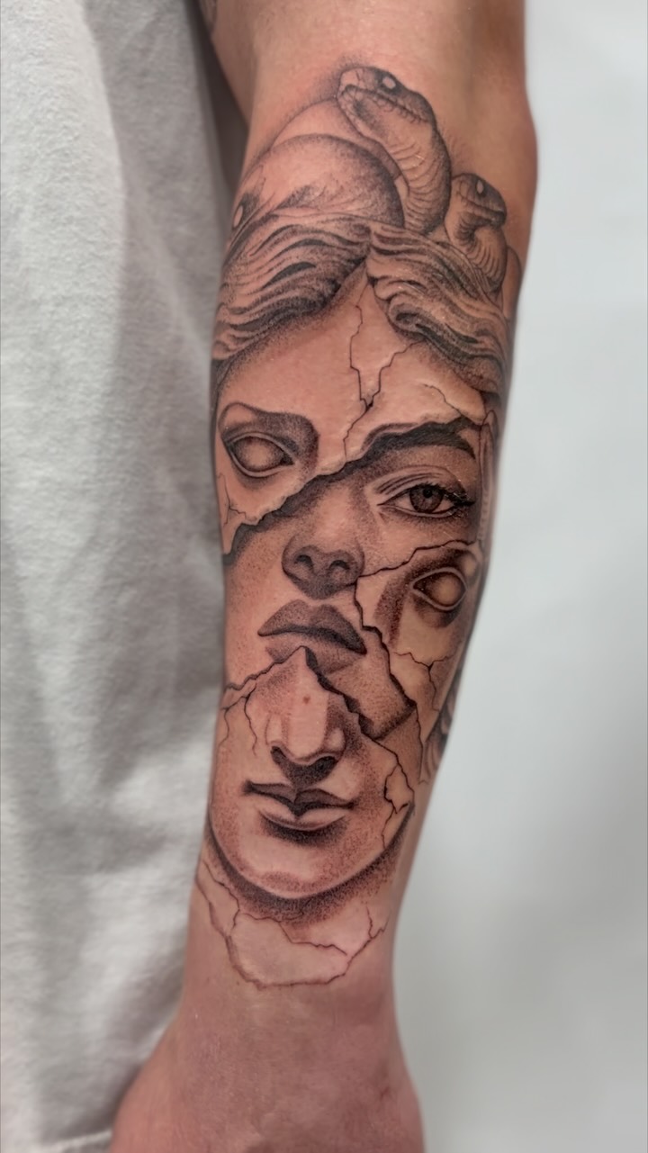 Cracked marble Medusa bust with entwined snakes, grayscale