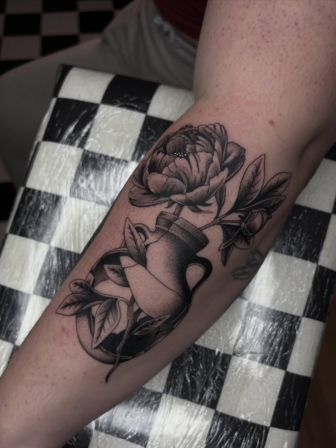 Bold black-and-gray peony bouquet in a vase on calf