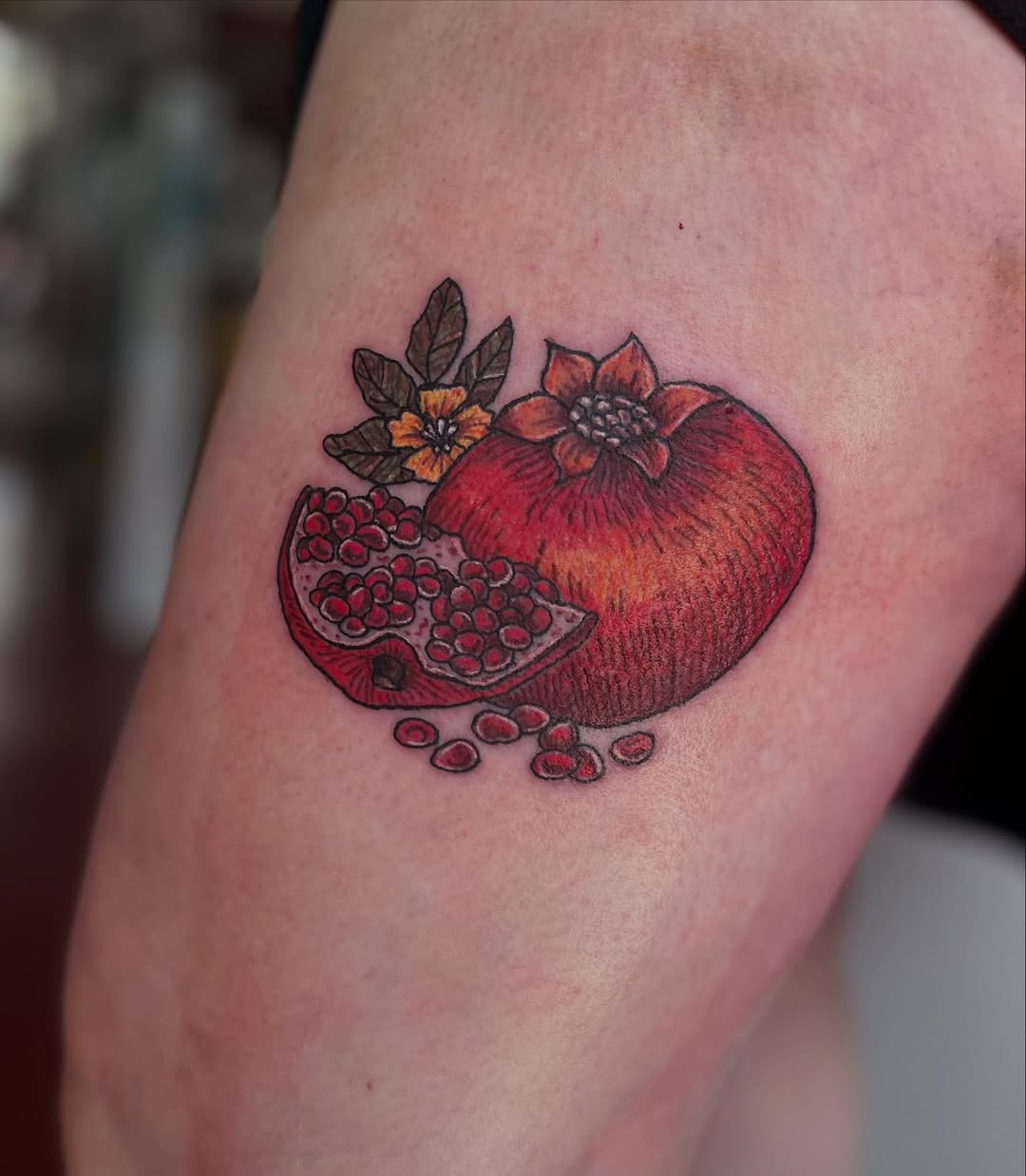 Vibrant pomegranate with split seeds and floral accents