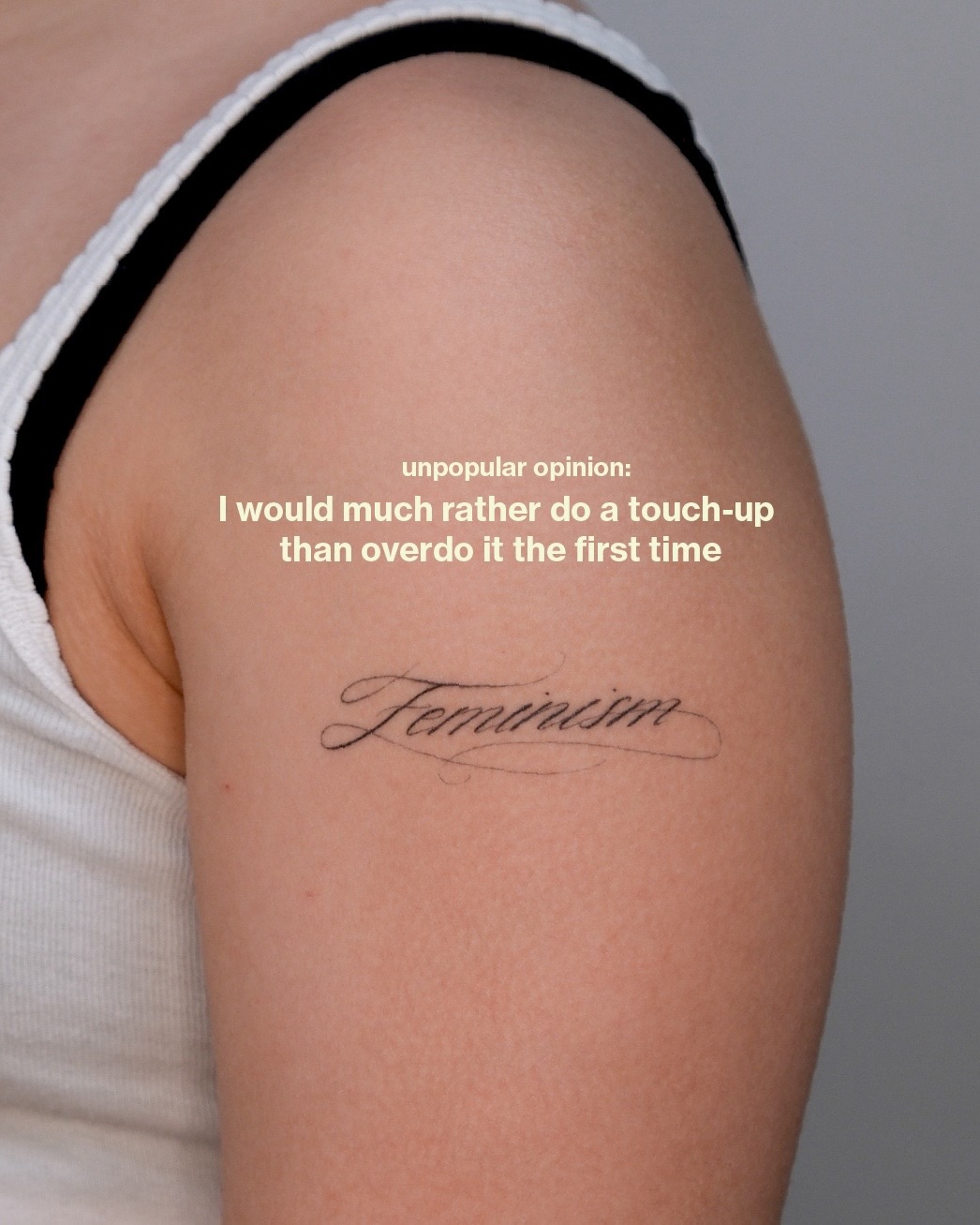 Elegant cursive script reading 'Feminism' on the upper arm.