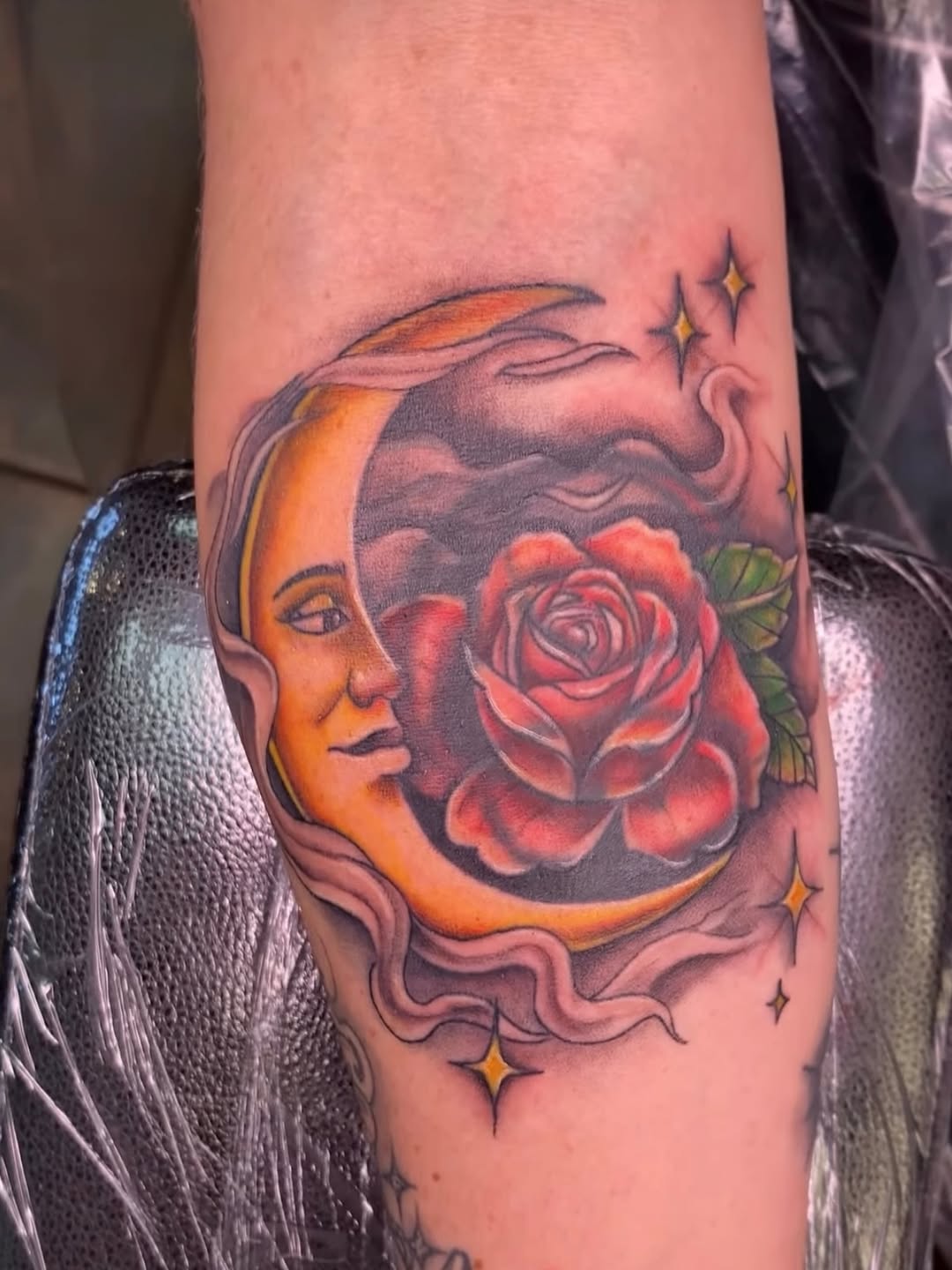 Whimsical crescent moon with a face and vibrant rose