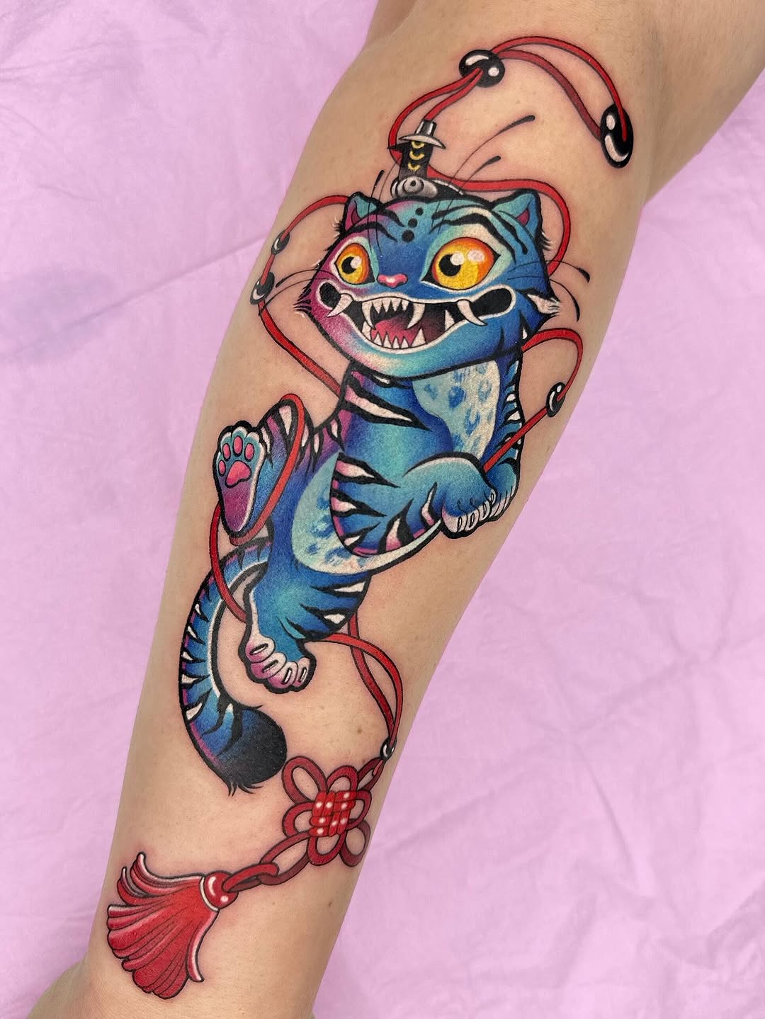 Bold neon-blue tiger-cub with red cords.