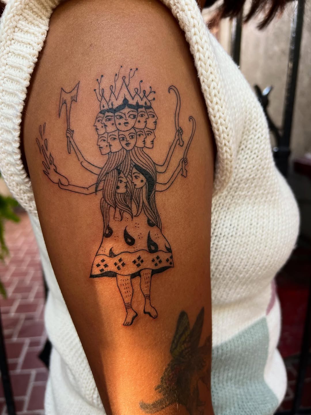 Intricate multi-headed goddess with crown and many arms