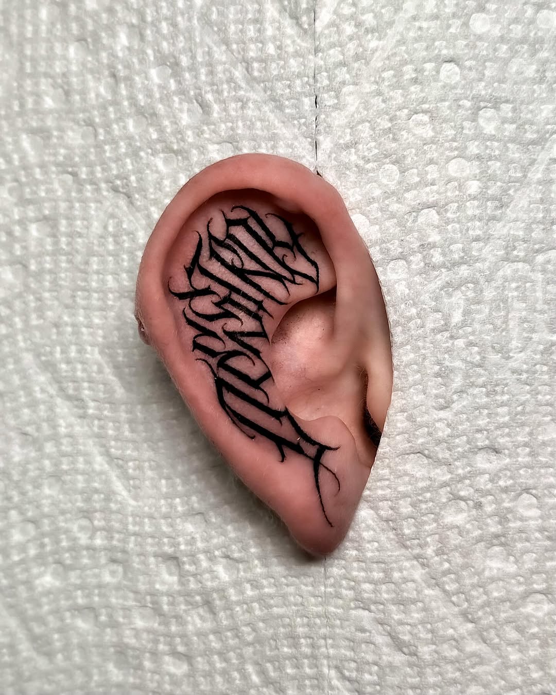 Freehand black-letter earpiece with flowing angular script