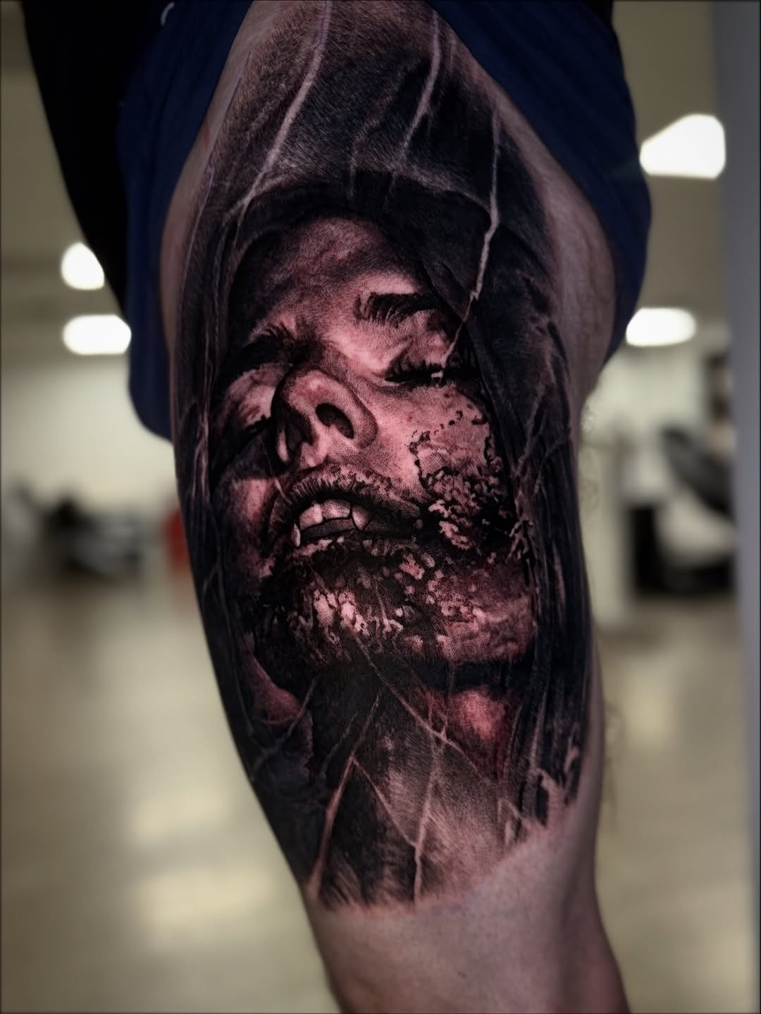 Haunting hyper-realistic black-and-gray female portrait on thigh.