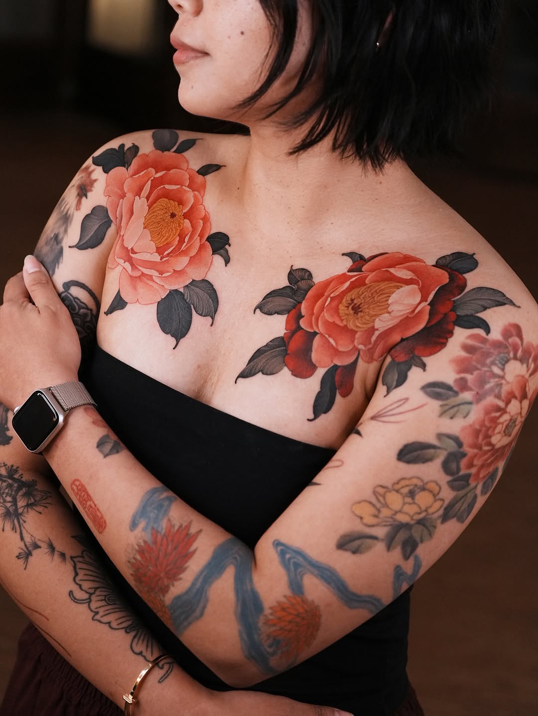 Two bold peonies span shoulders to chest in color