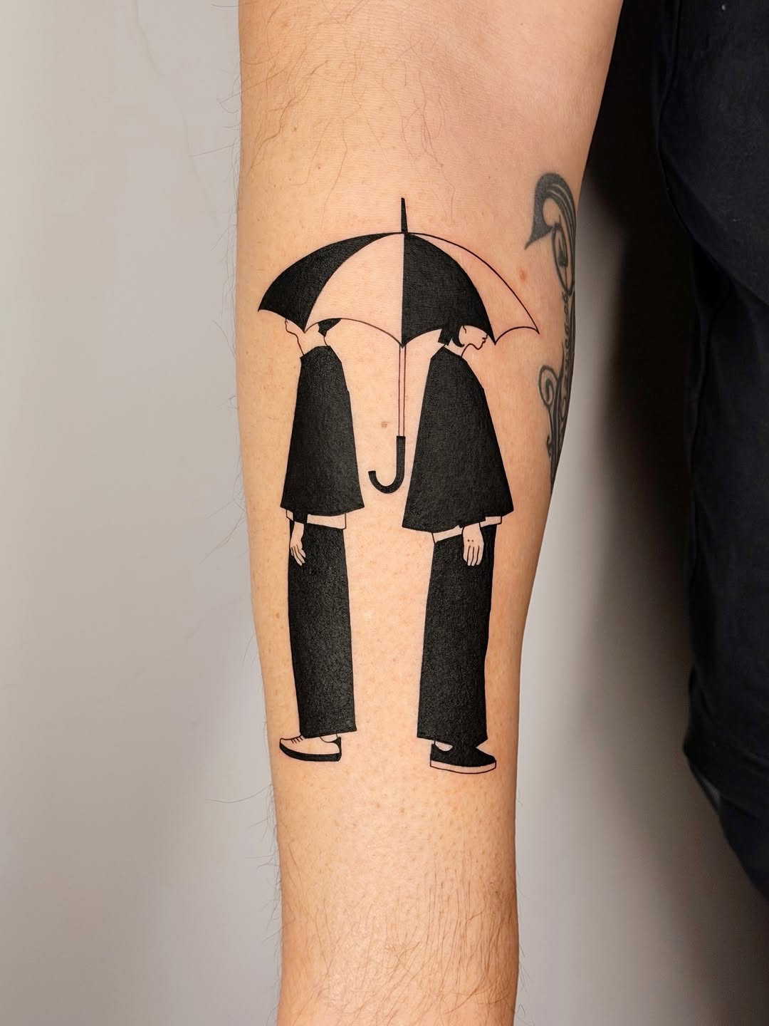 Two silhouetted figures share umbrella in bold blackwork.