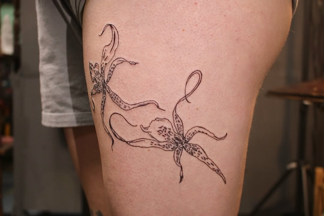 Delicate fineline orchids with flowing, graceful stems on thigh