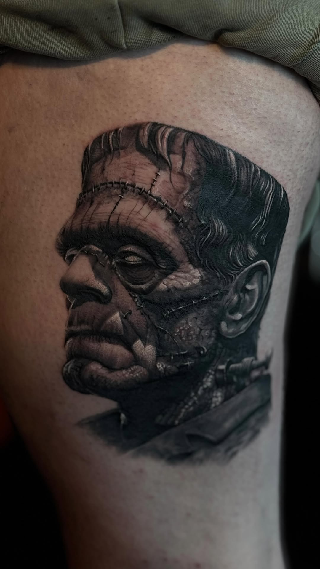Hyper-detailed black-and-gray Frankenstein portrait with stitched scars.