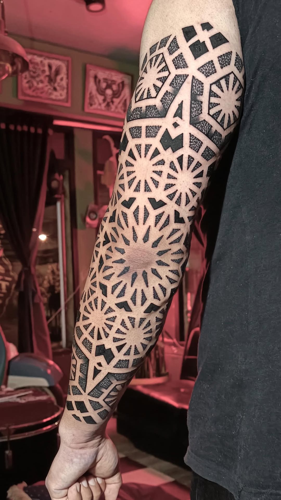 Intricate geometric starburst tattoo with negative-space lattice