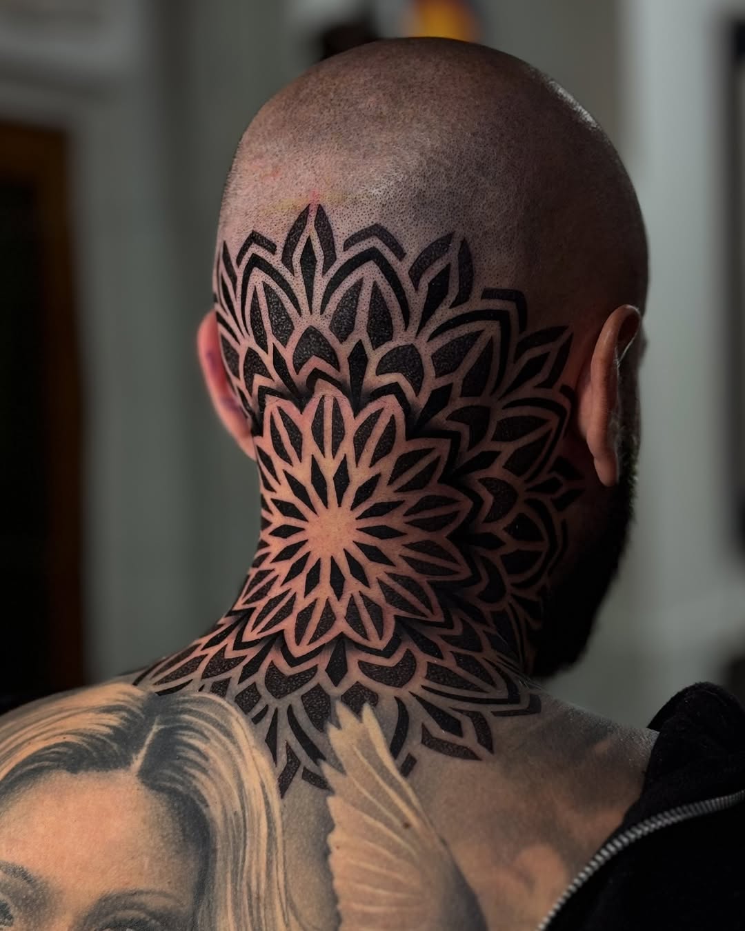 Intricate blackwork mandala neck tattoo with radiant petals.