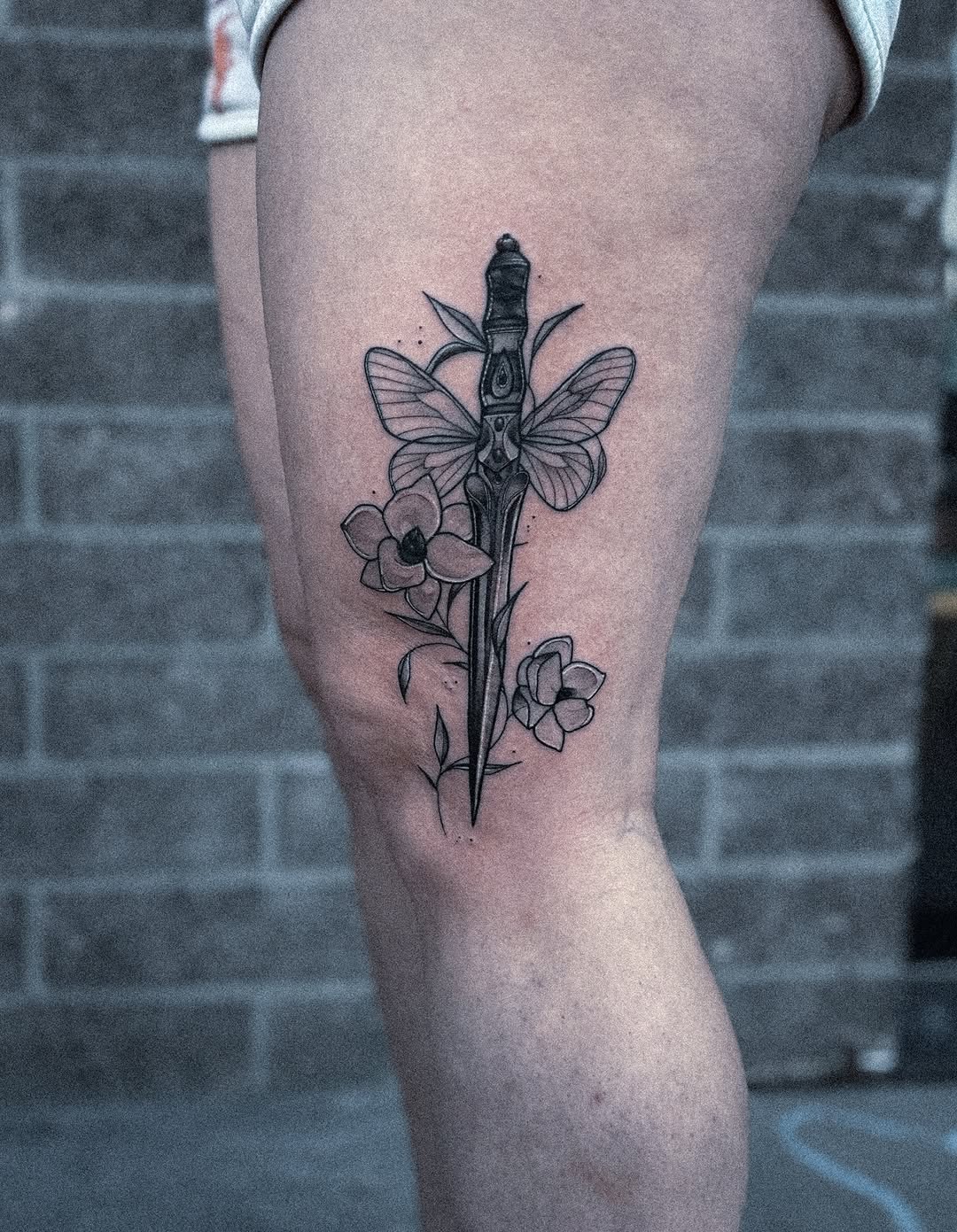 Stylized dagger with moth wings and orchid blooms