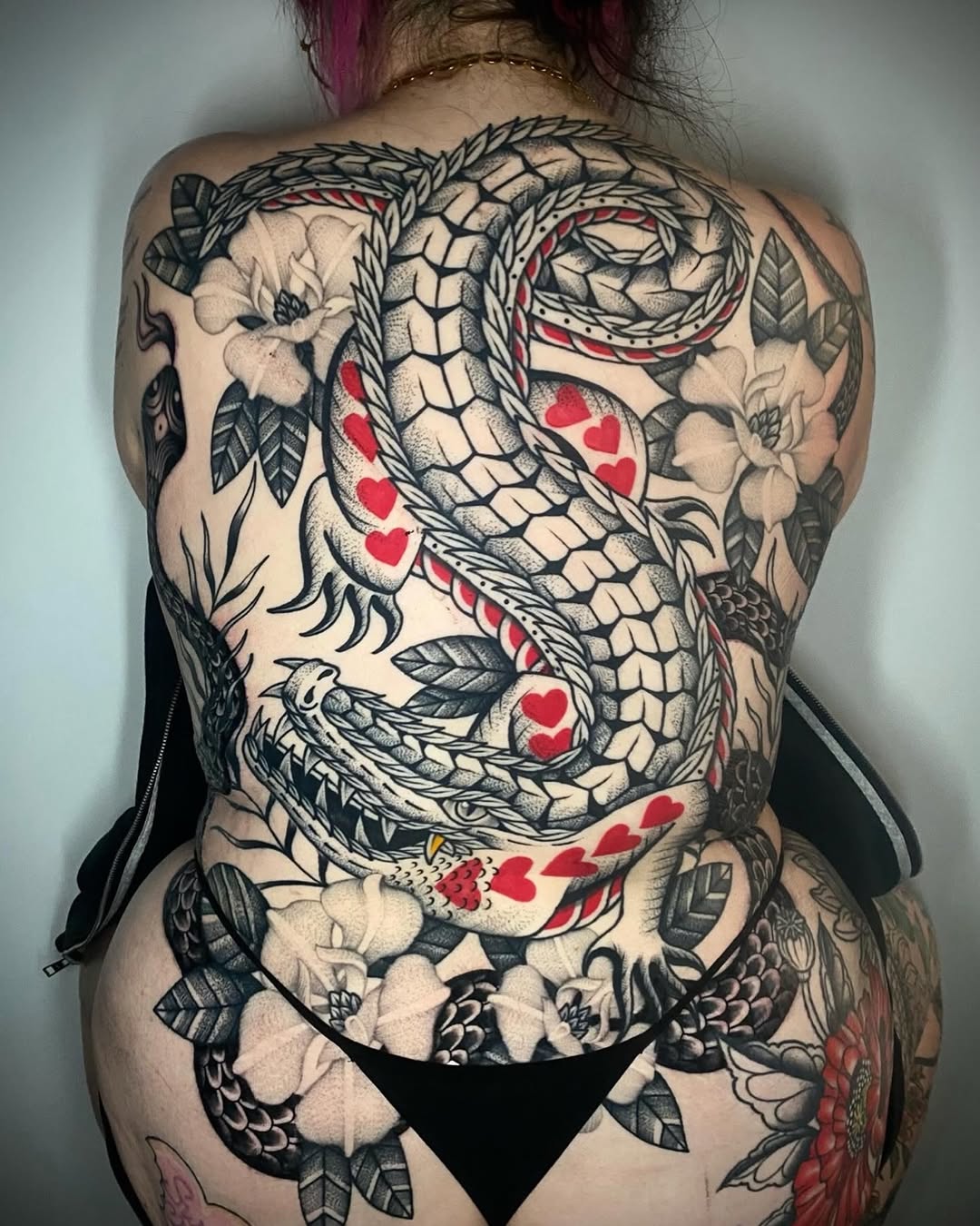 Bold black serpent coils across back with red hearts