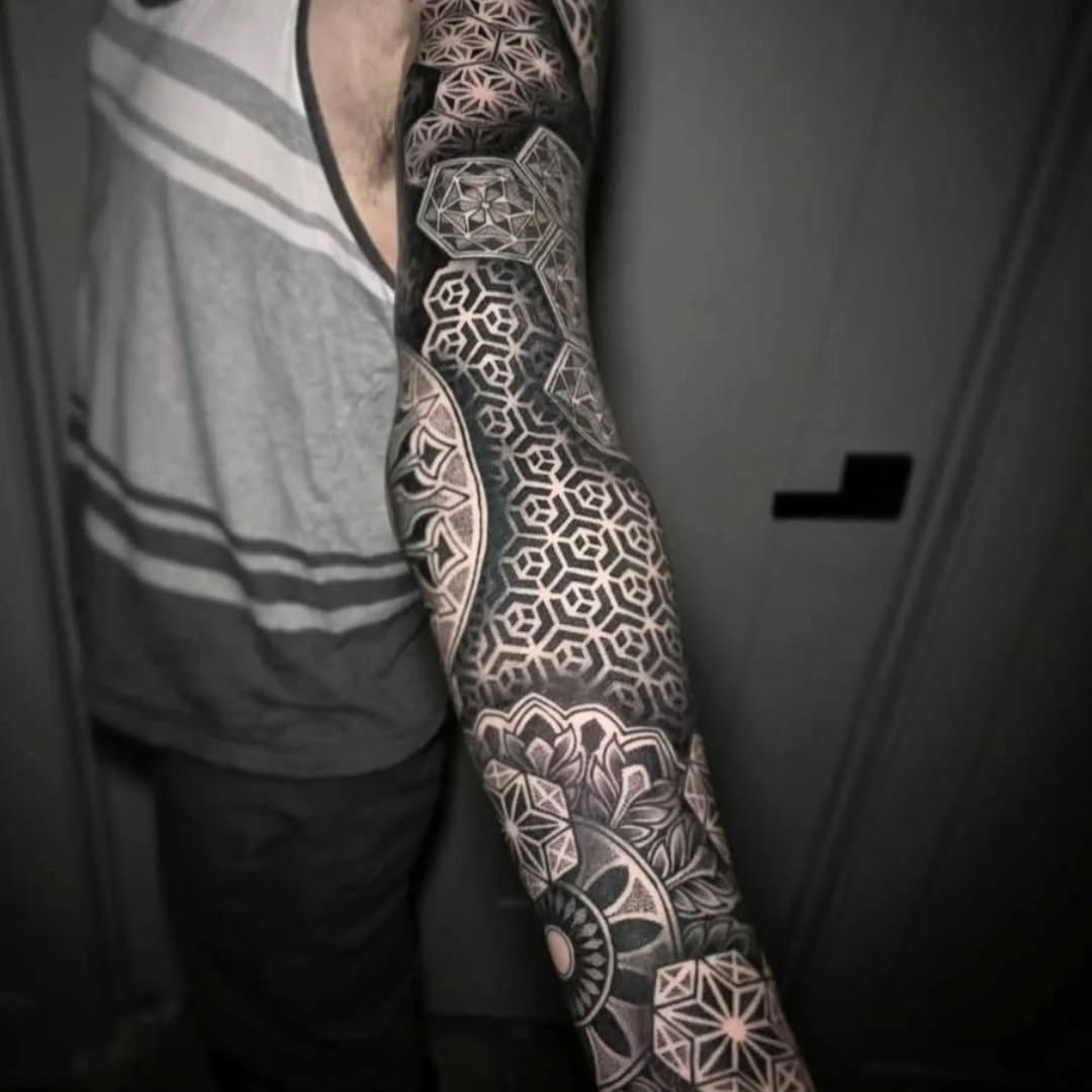 Intricate black-and-gray geometric sleeve with mandala motifs.