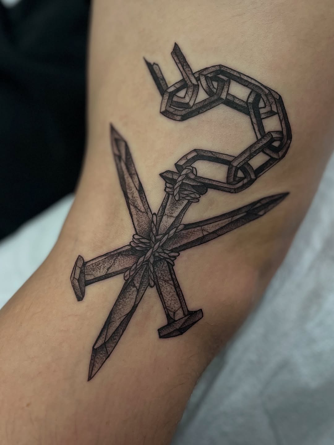 Bold rope-wrapped cross of twin swords with chain links