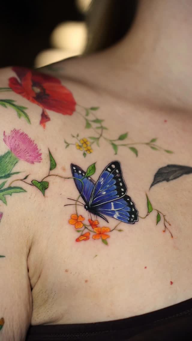 Vibrant watercolor butterfly amid delicate florals and vines