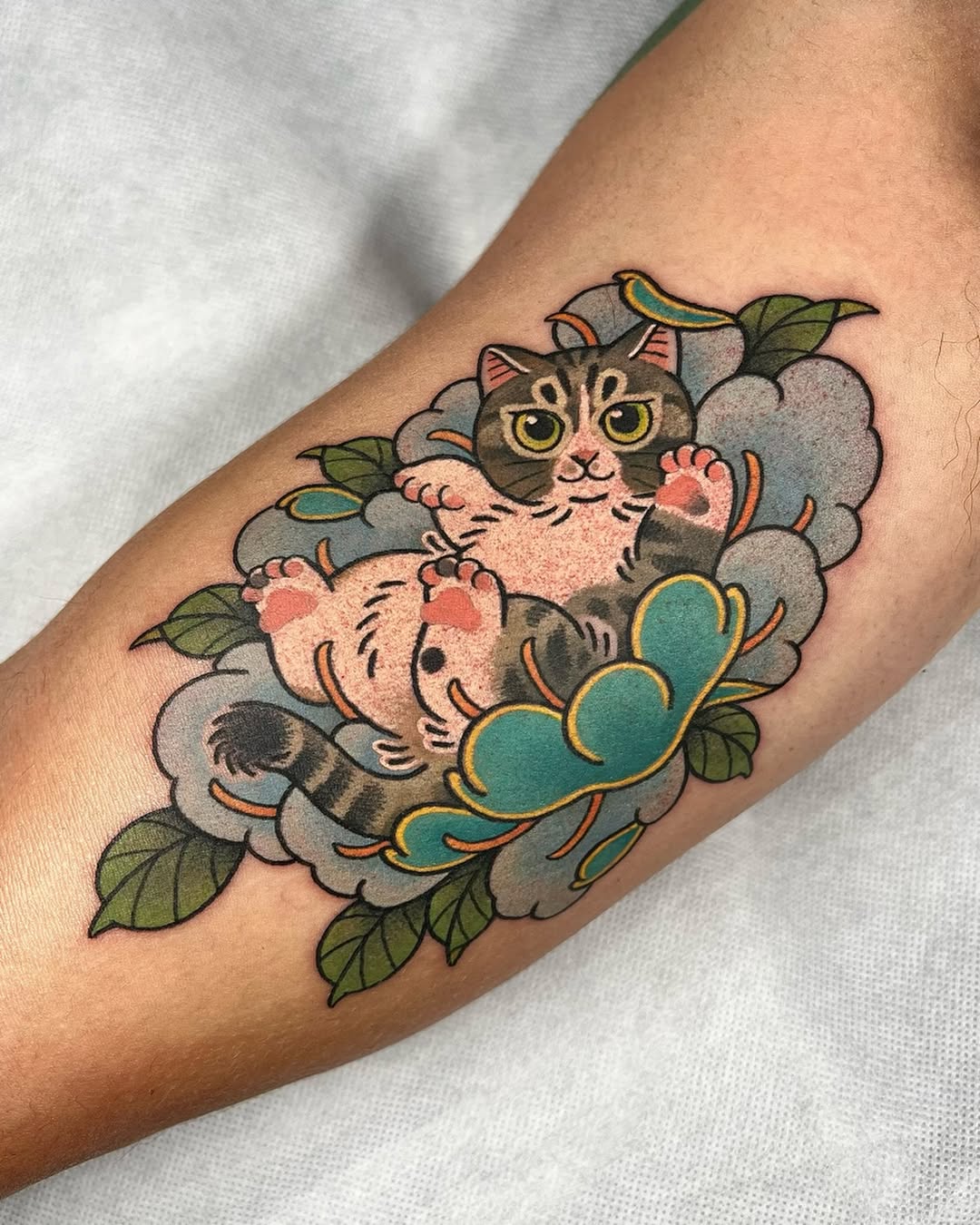 Playful chubby cat floating on blue-gray clouds.