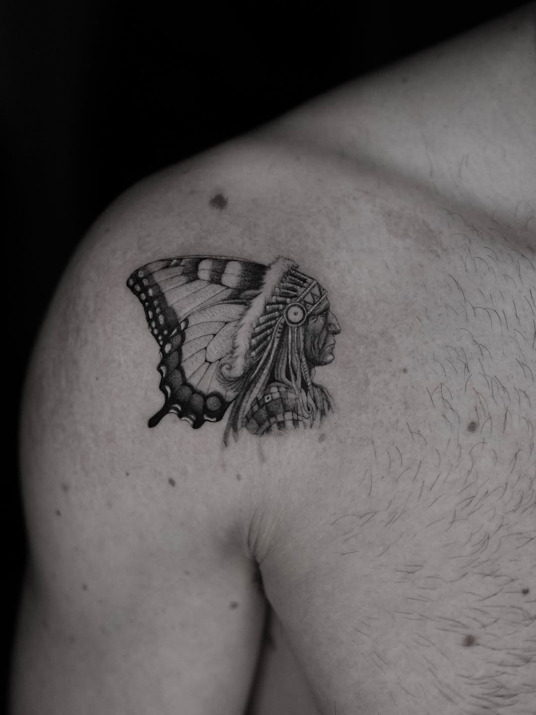Black-and-gray butterfly merged with Native-inspired feather headdress.