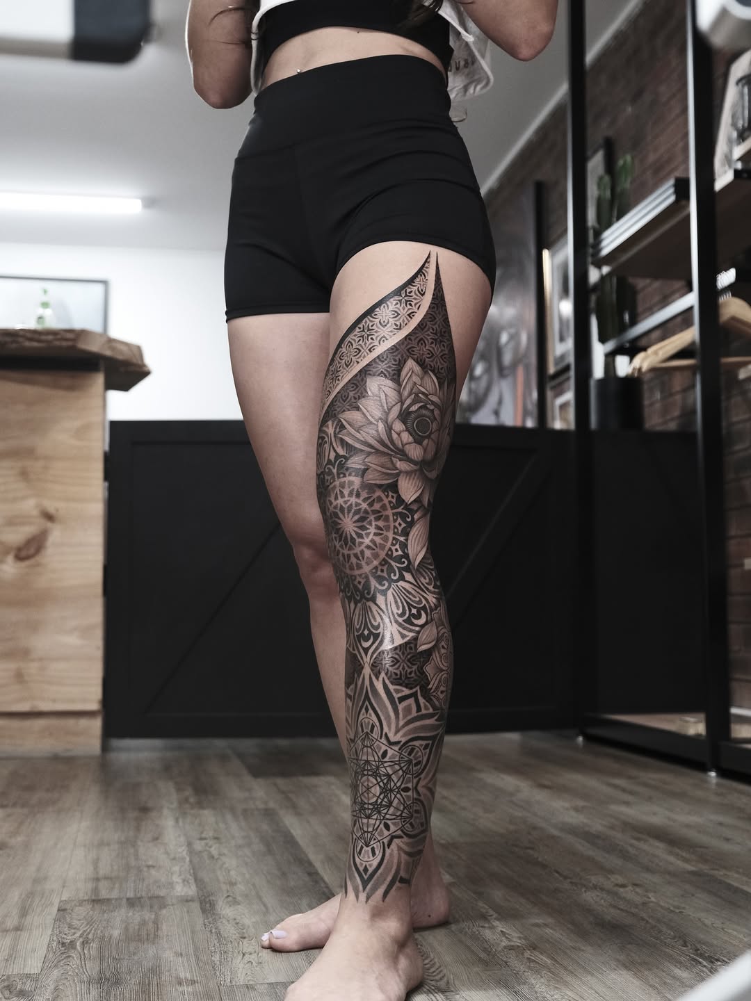 Intricate blackwork leg sleeve with floral mandala motifs
