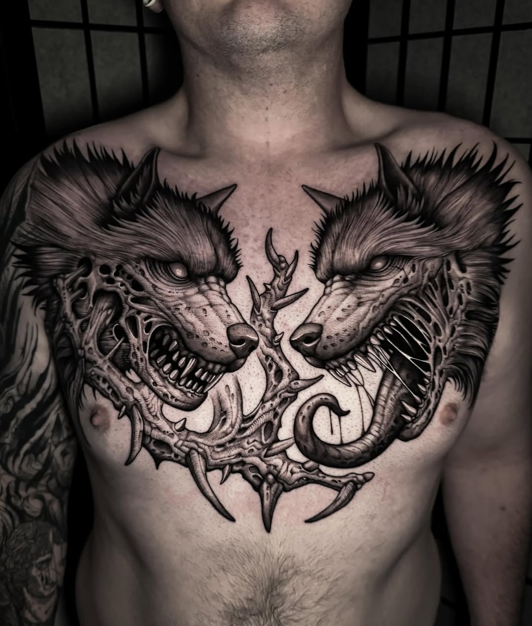 Symmetrical blackwork wolves, fierce, skeletal forms across chest.