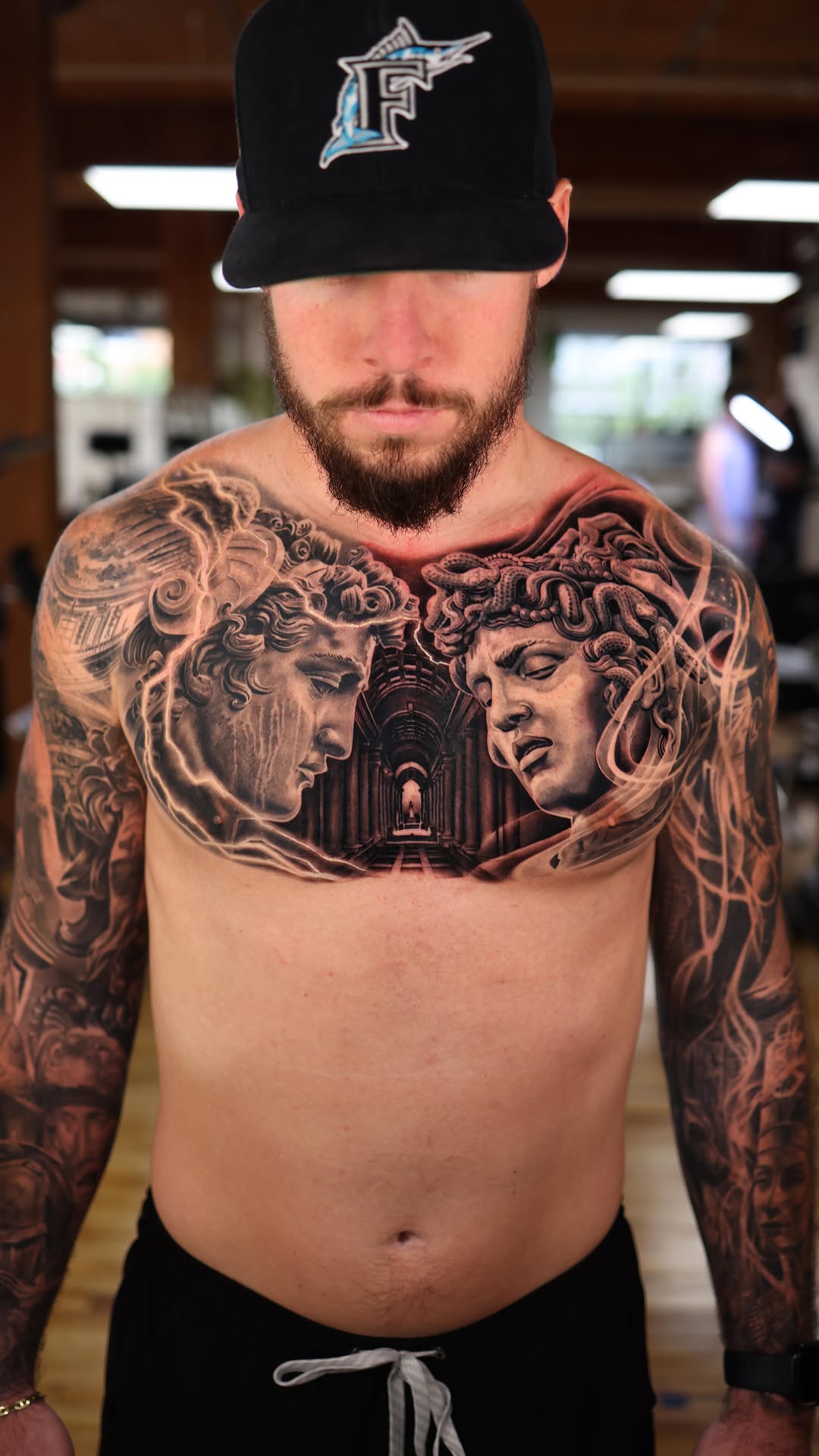 Monumental black-and-gray Perseus and Medusa chest piece.