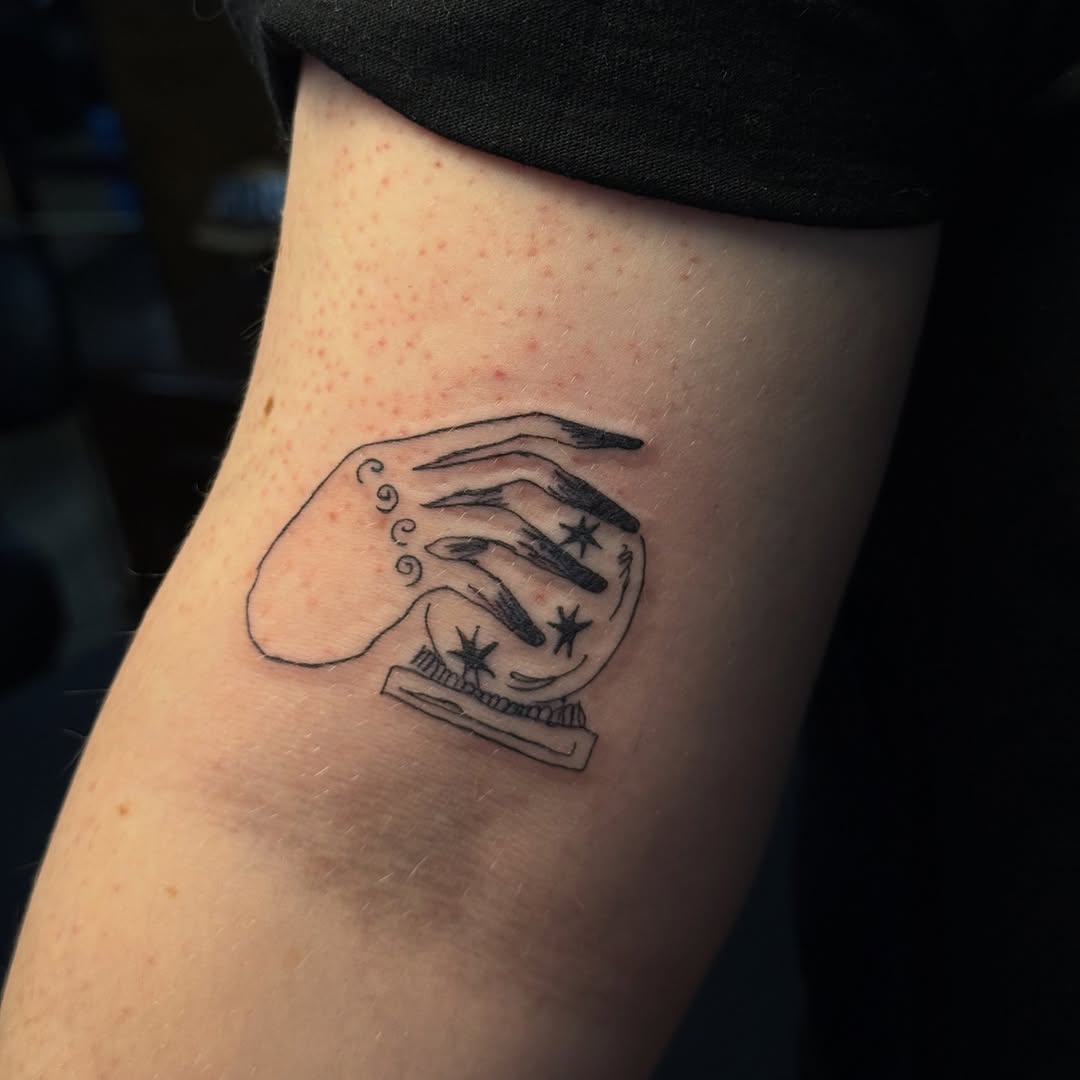 Creepy fortune-teller hand over a starry crystal ball