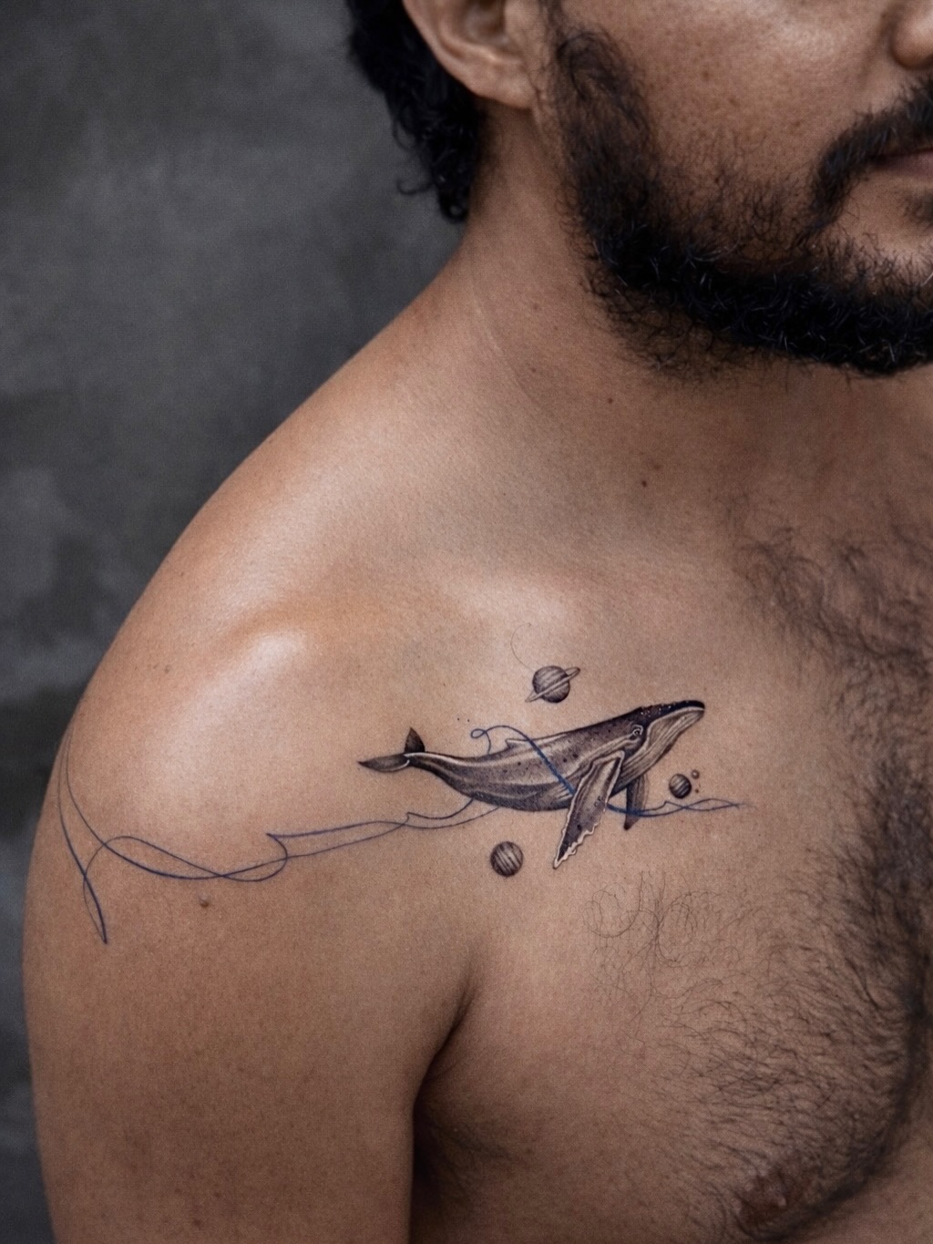 Delicate fine-line whale with orbiting planets and cosmic ocean.