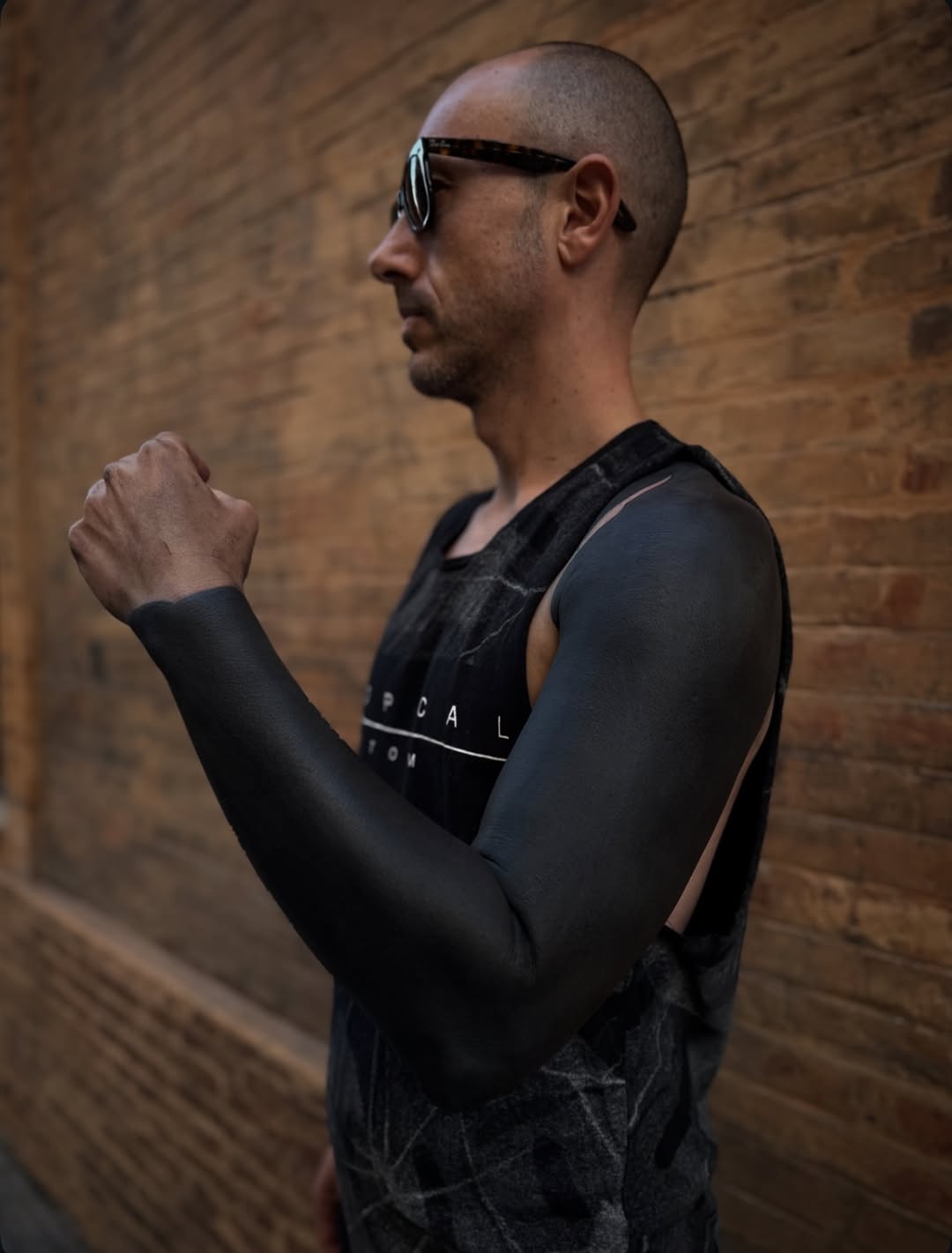 Bold solid blackout sleeves on both arms.