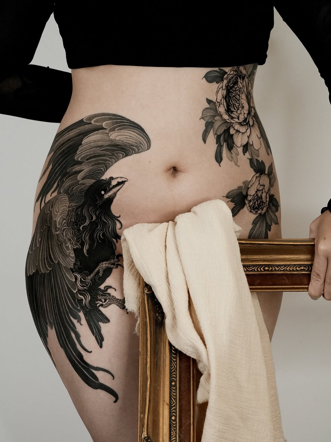 Dark raven with expansive wings, paired with blooming peonies