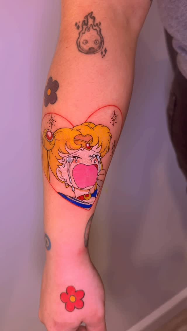 Vibrant Sailor Moon crying tattoo framed by a heart