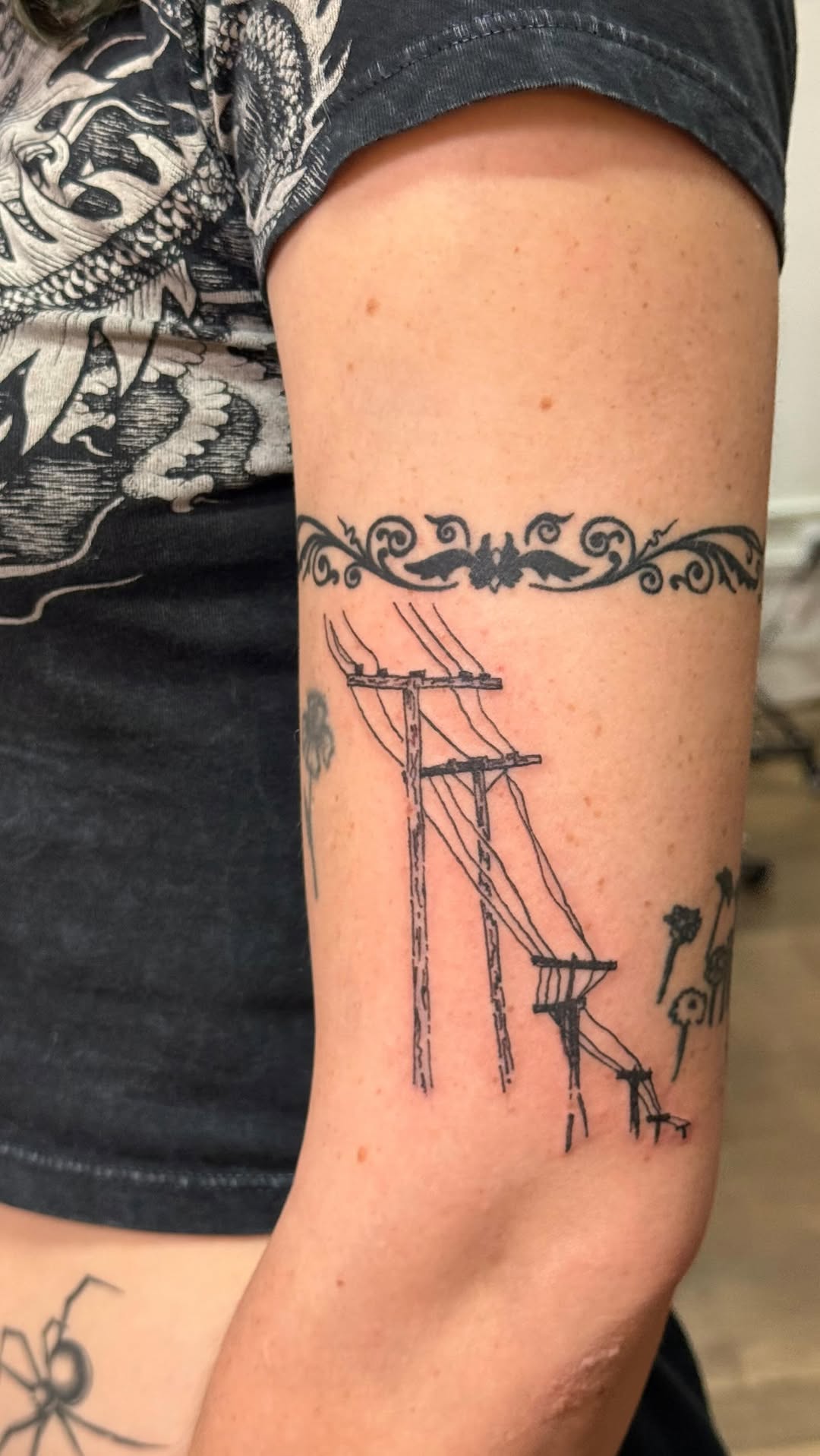 Fine-line power-pole scene under an ornate floral band