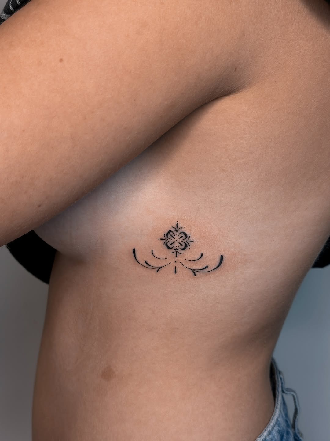 Delicate fineline floral ornament with symmetrical curves.