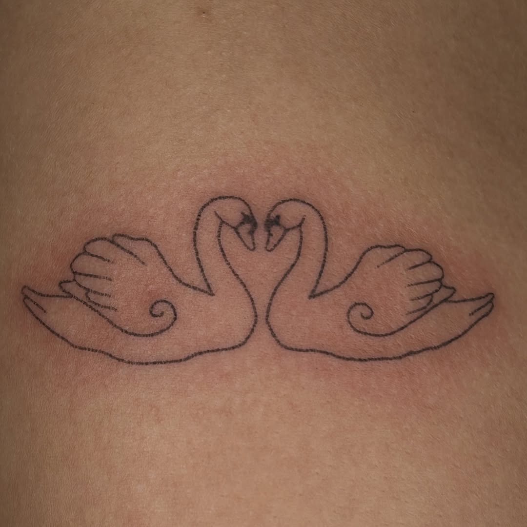 Two swans form a heart through minimalist linework.